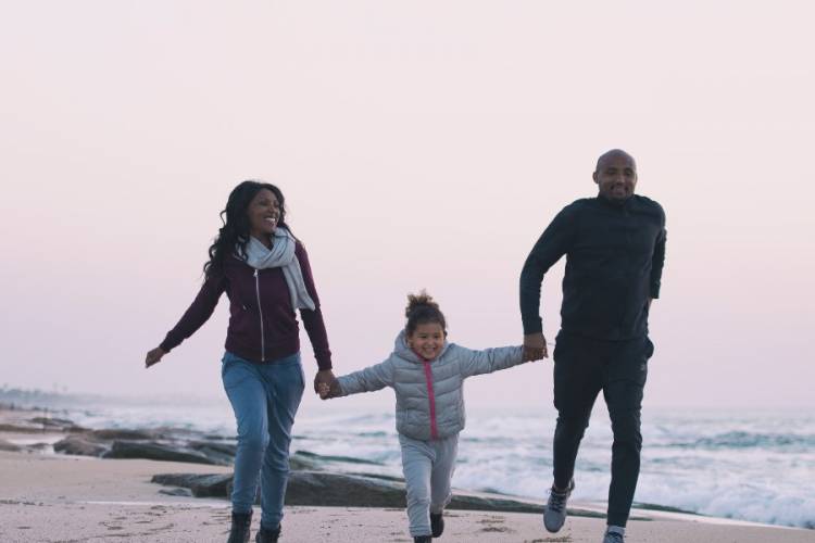 Family walking on beach in the winter