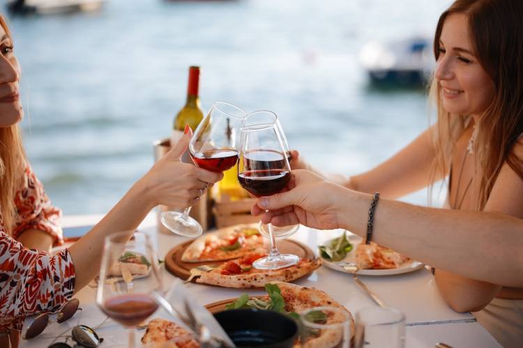 Friends eating dinner by the water