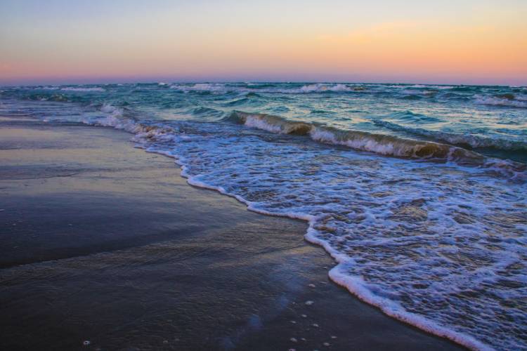 waves crashing on shore at sunset