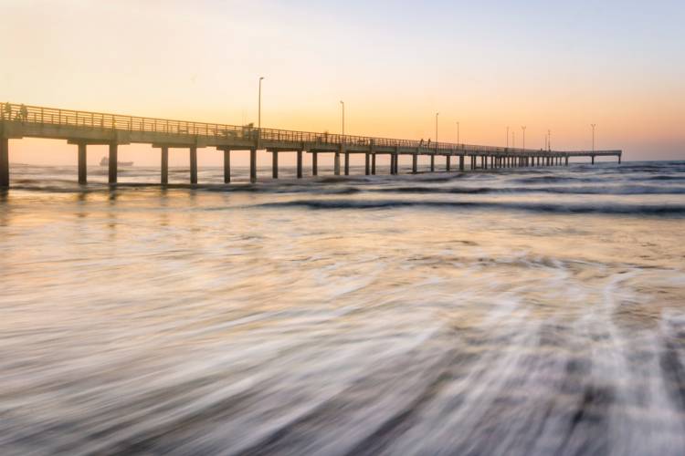 Long Exposure of Waves Washing on Shore by Port Aransas Pier at Sunset Near Aransas Princess Resort