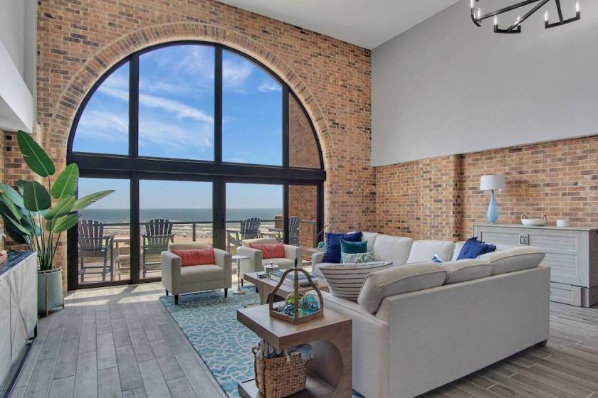 interior of vacation rental in port aransas. exposed brick and large arched window with Gulf view