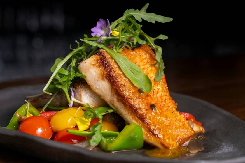 Grilled fish on top of vegetables