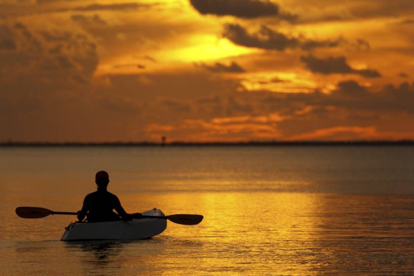 woman in kayak at sunset